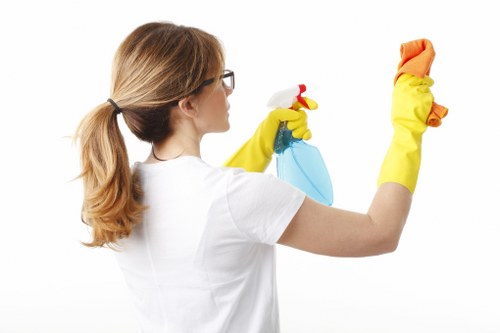 Domestic cleaner in Edgware tidying a bright family living room